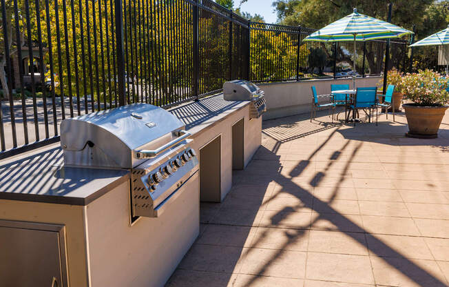 A patio with a grill and chairs.