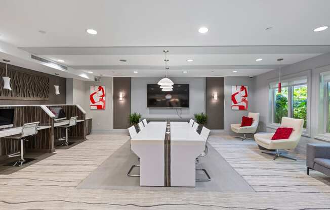 a conference room with a white table and chairs and a television