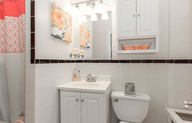 a bathroom with a sink, toilet and mirror at the calverton apartments in washington dc
