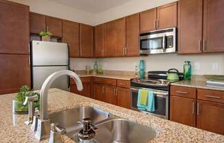 A kitchen with brown cabinets and a granite countertop.