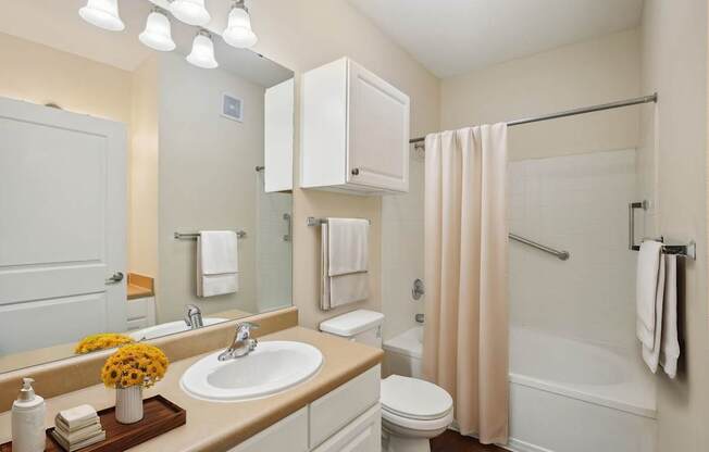 A bathroom with a sink, toilet, and bathtub.