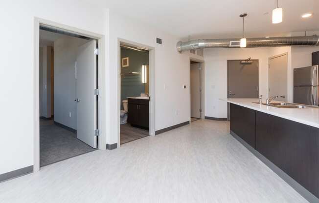 Modern open-concept kitchen and living area with stainless steel appliances.