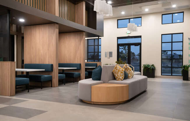 A modern waiting room with a wooden reception desk and comfortable seating.