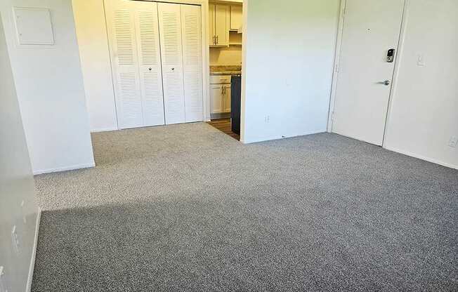 A dining room with a carpeted floor and a closet at Waverly Park Apartments, Lansing