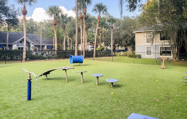 A park with a blue mat and a slide.