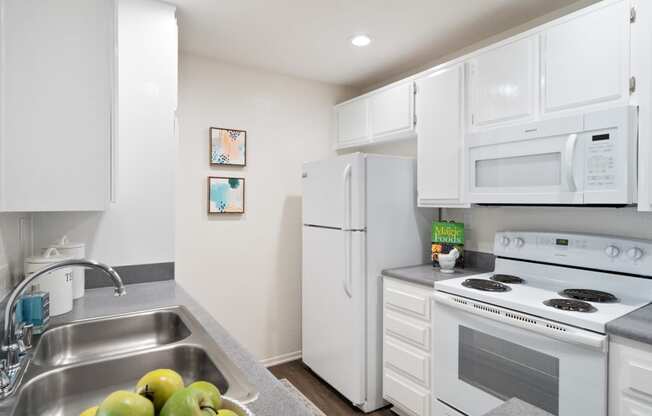 a kitchen with white appliances and a sink