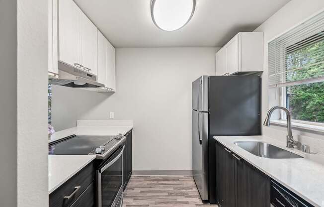A kitchen with black appliances and white cabinets.