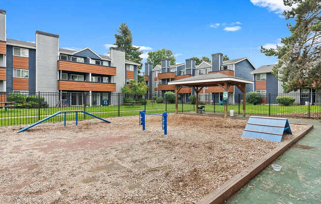 A playground with a slide and swings in front of apartment buildings. at Northpoint Apartments, Tacoma, WA
