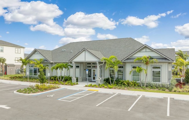 an empty parking lot in front of a building with palm trees