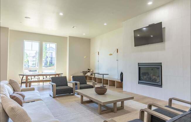 A living room with a grey couch, a wooden coffee table, and a television mounted on the wall at Northplace Apartment Homes, Oregon, 97305