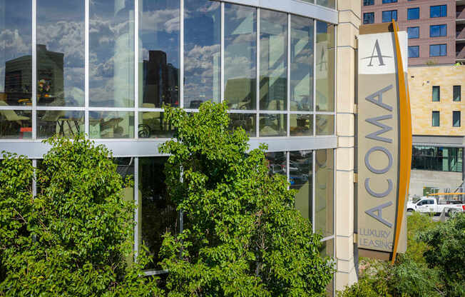 A building with a sign that says ACOMAA in front of it.