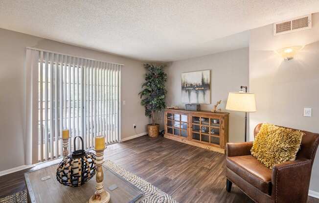 A living room with a brown leather couch and a wooden cabinet.