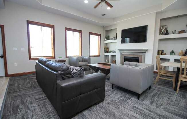 A living room with a grey couch and a fireplace.