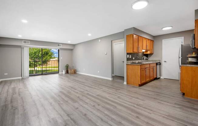 A spacious kitchen with wooden cabinets and a marble countertop.