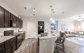 an open kitchen and living room with a large counter top