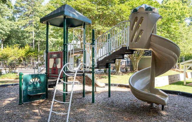 a playground with a slide and other toys in a park