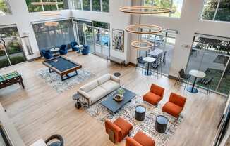 a large living room with a pool table and couches