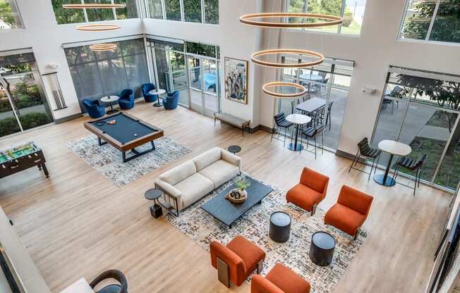 a large living room with a pool table and couches