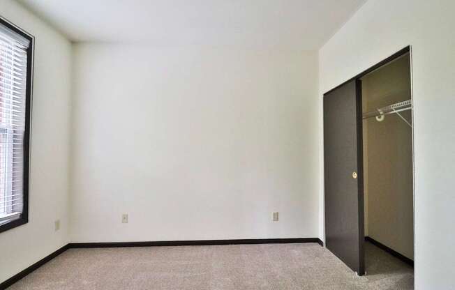 A room with a carpeted floor and a door on the right side.