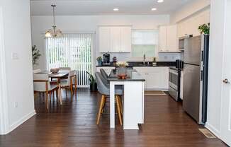 A kitchen with a dining table and chairs.