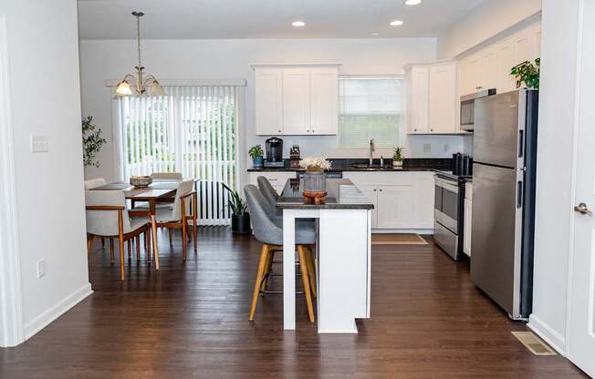 A kitchen with a dining table and chairs.
