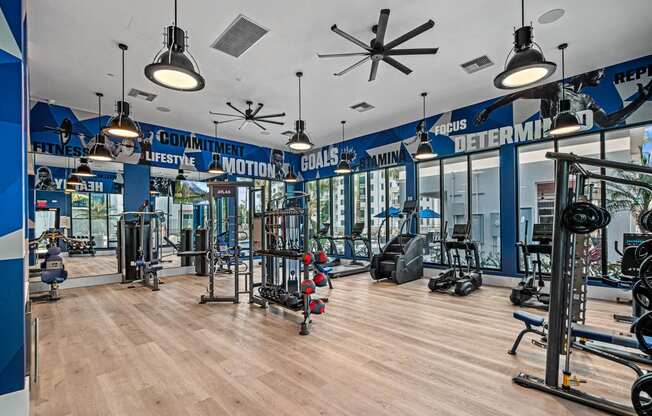 a gym with weights and cardio machines and lights on the ceiling at Altis Santa Barbara, Naples, FL
