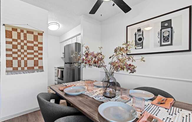 a dining room with a table with plates and chairs