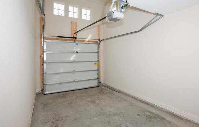 a garage with white walls and a clear garage door