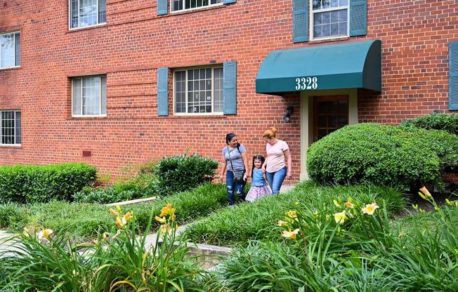 two women and a child walking in front of a brick building at Hamilton Manor Apartments, Hyattsville