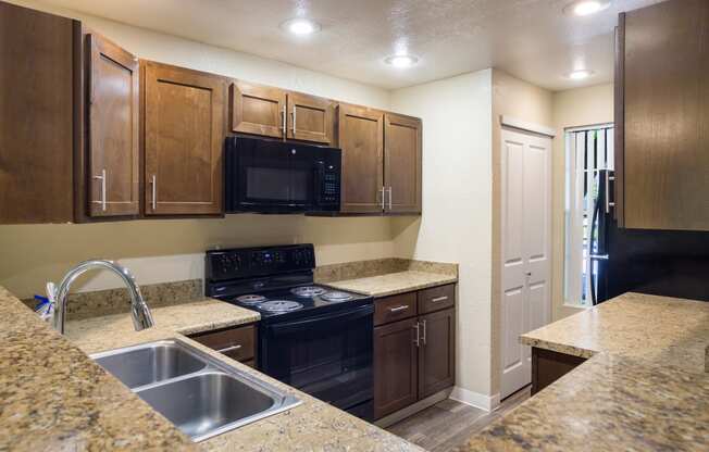 A kitchen with wooden cabinets and granite style countertops at Arcadia Townhomes, Federal Way, WA