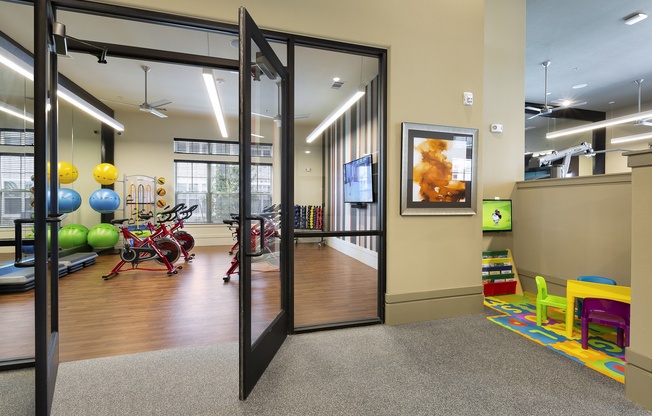 a gym with a variety of exercise equipment and glass doors at North Creek, Texas, 78634