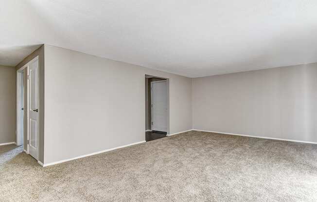 Living room with carpeted floors in a 2-bed, 1-bath apartment at Ashton Brook.