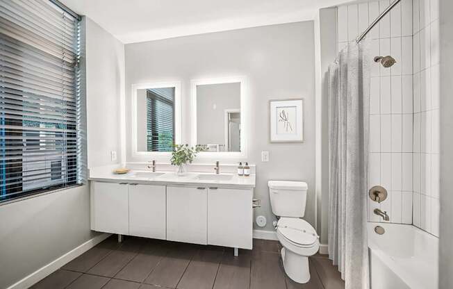 A white bathroom with a toilet, sink, and shower.