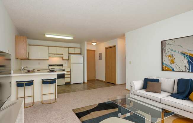 Fargo, ND Twin Parks Apartments. a living room with a white couch and a glass coffee table