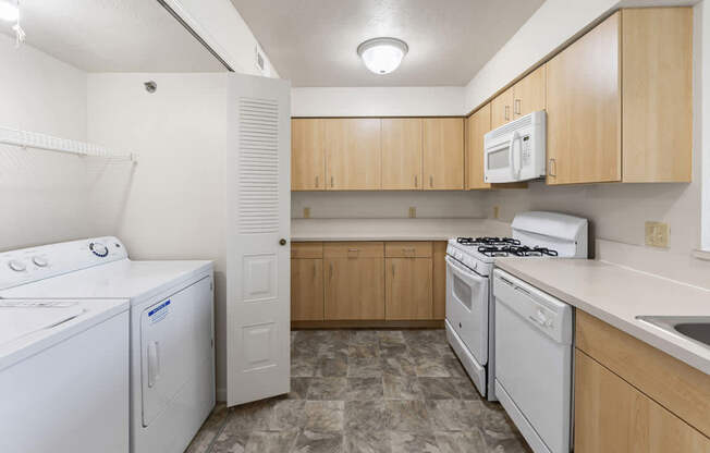A kitchen with a washer and dryer at Colonial Pointe at Fairview Apartments, Bellevue, 68123