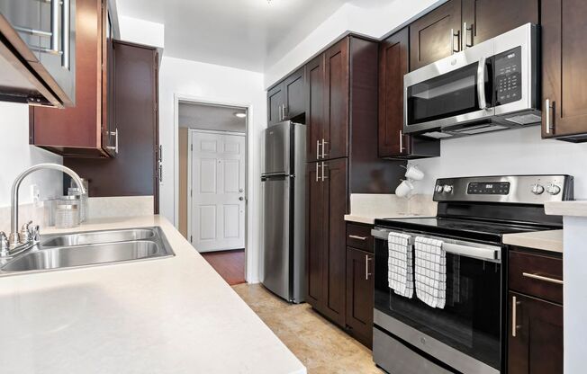 Apartments for Rent in Encino - Large Kitchen with Stainless Steel Appliances and Dark Brown Cabinets.