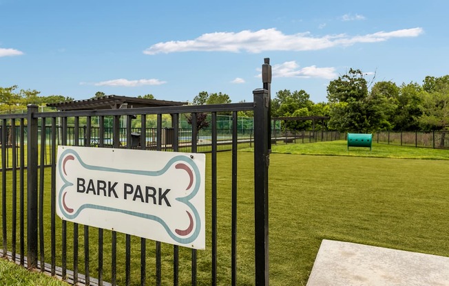 A sign that says Bark Park is on a black fence.