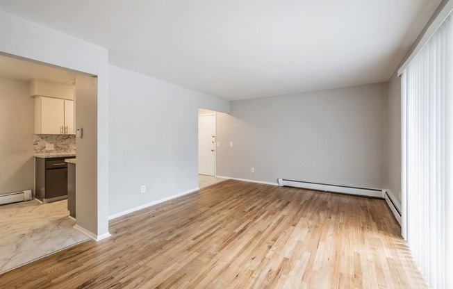 an empty living room with wood flooring and white walls