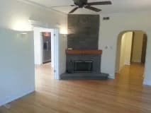 living room with a fireplace and a ceiling fan at Bryant II