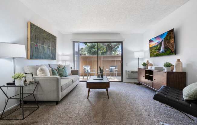 a living room with a couch and a coffee table and a large window