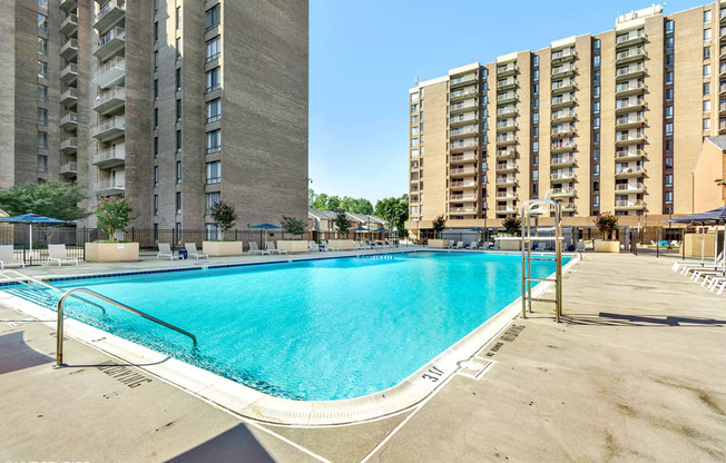 a swimming pool with an apartment building in the background