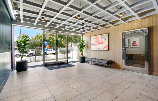 a lobby with a glass door and a glass wall with a view of the street at The Kenmore Los Feliz, Los Angeles, CA