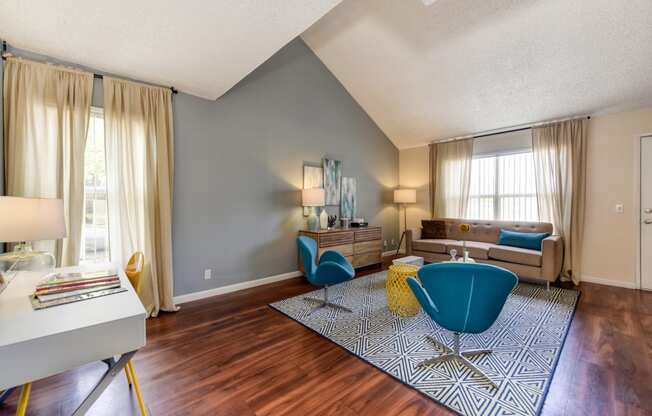 Model home living room with hardwood inspired flooring and vaulted ceilings 