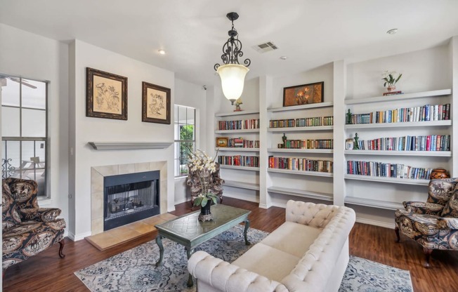 a living room with a fireplace and bookshelves at St. Augustine Estate, Dallas, TX 75227