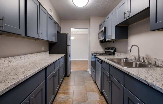 redesigned kitchen with granite countertops and dark cabinets and stainless steel appliances at the reserves