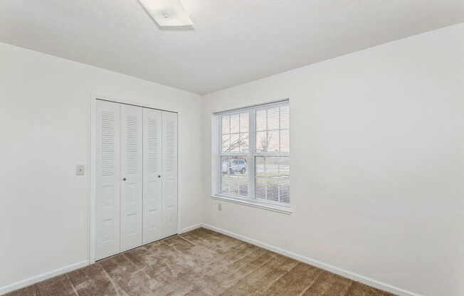 a bedroom with a window and a closet