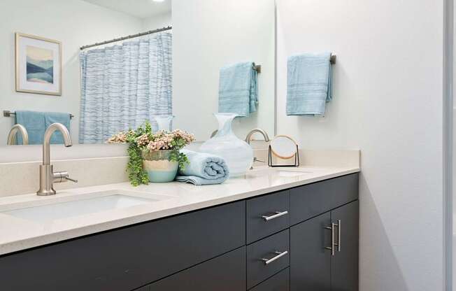 A bathroom with a sink, mirror, and towels.