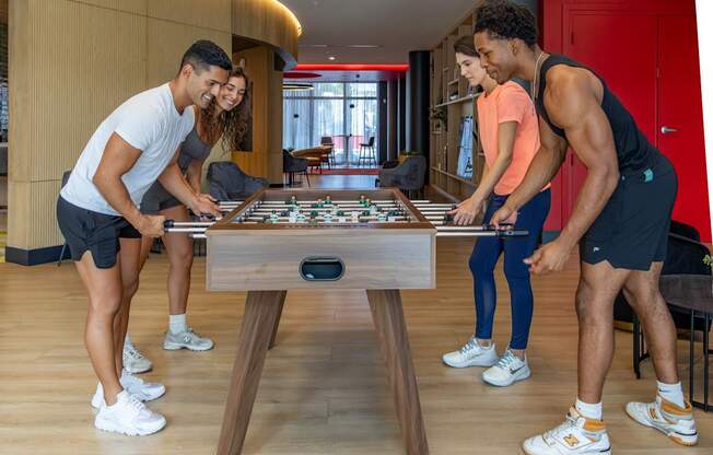 Four people playing a game of Foosball at Icon One, Daytona Beach