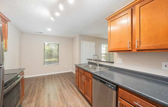 an empty kitchen with wood cabinets and a counter top and a sink