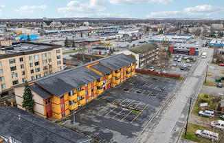 A parking lot in front of a multi-story building.
